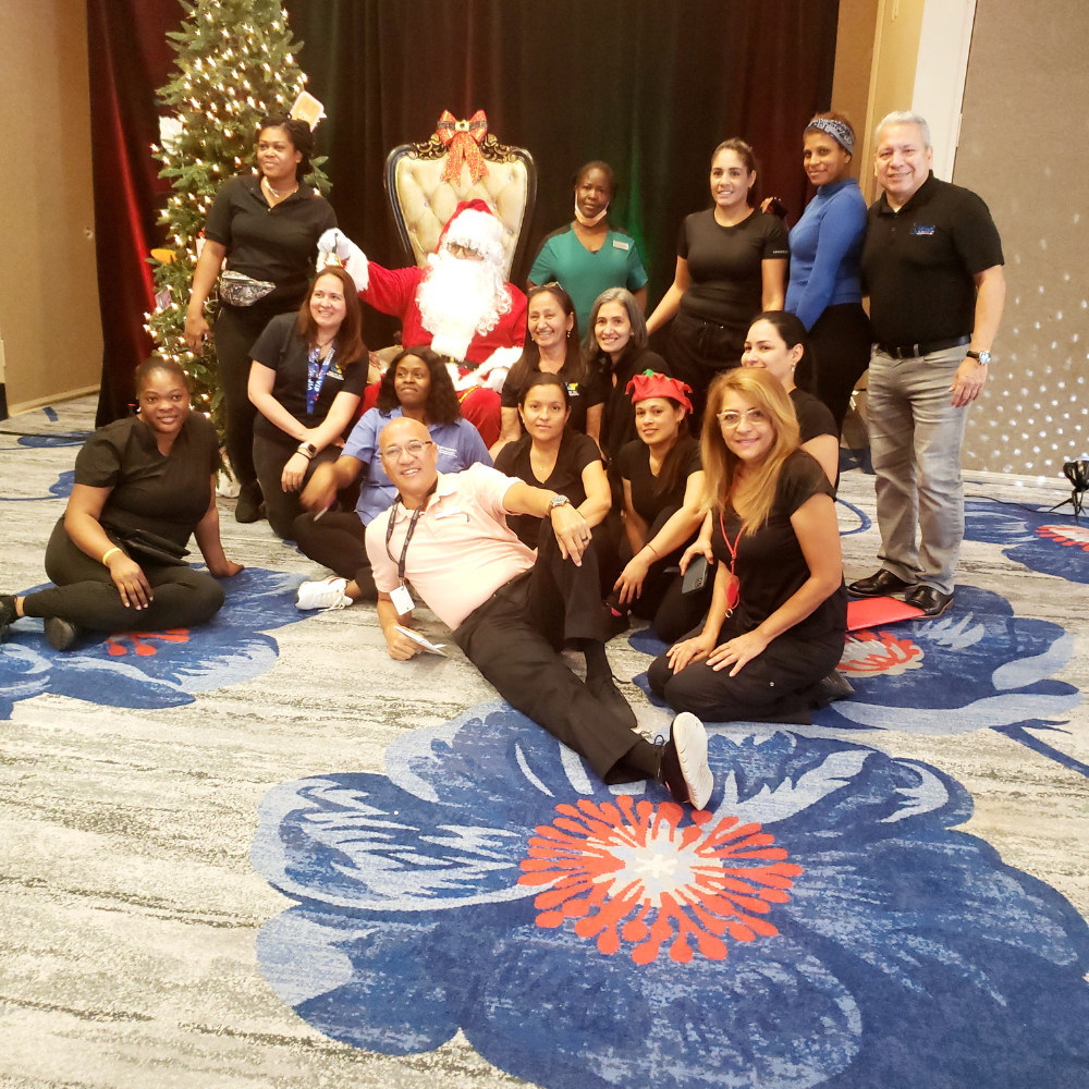 VillaPower Global Services team members posing with Santa Claus at a holiday party