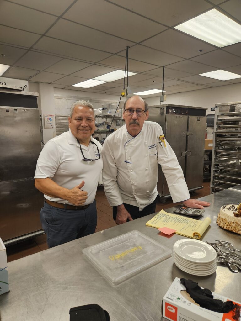 Staffing agency manager poses with executive chef in a kitchen